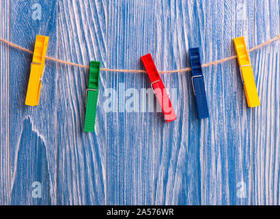 Colorful plastic clothespins on blue wooden background Stock Photo