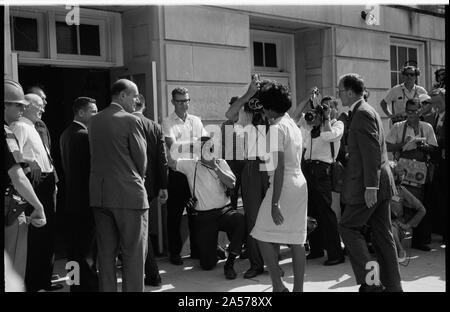 Vivian Malone entering Foster Auditorium to register for classes at the University of Alabama.  Vivian Malone, one of the first African Americans to attend the university, walks through a crowd that includes photographers, National Guard members, and Deputy U.S. Attorney General Nicholas Katzenbach. Stock Photo