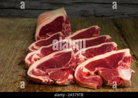 Fresh English Lamb Loin Chops, on a butchers chopping block. Stock Photo