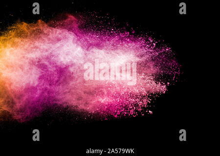 Abstract pink and orange powder explosion on  black background. Freeze motion of pink orange dust splashing. Stock Photo