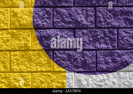 Close up on Colourfully painted yellow, white and purple brick wall Stock Photo