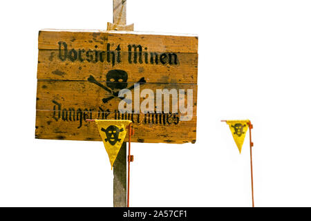 German World War Two wooden Vorsicht Minen / Caution Land Mines warning sign and marker flags marking minefield / minefield against white background Stock Photo