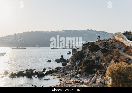 Mykonos, Greece - September 19, 2019: People walking on the path over the hill between Hidden and Platis Yialos beaches in Mykonos, a popular travel d Stock Photo