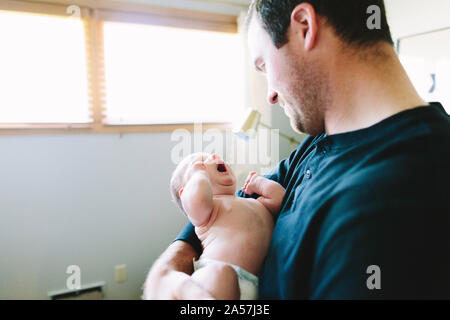 A new dad holds his tired newborn son Stock Photo