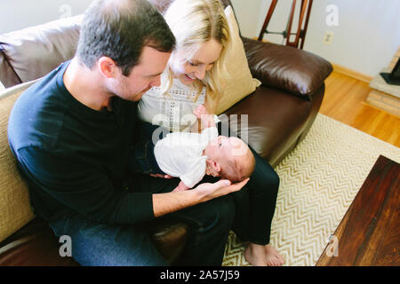 View from above of first time parents holding their newborn baby son Stock Photo