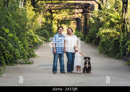 Happy family holding hands and petting dog on Steele Canyon Bridge Stock Photo