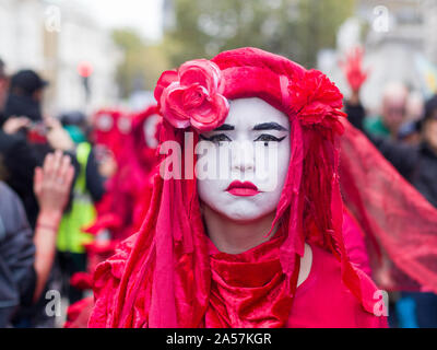Whitehall, London, UK. 18 October 2019. Environmental campaigners Extinction Rebellion, including Red Rebellion, families and young children protest along Whitehall to reach outside the gates of Downing Street. Activists sing and hold their hands which are painted red to symbolise blood. Protesters demand decisive action from the UK Government on the global environmental crisis.