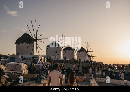 Mykonos, Greece - September 23, 2019:People gathering near windmills to watch sunset in Hora (Mykonos Town), capital of the island and one of the best Stock Photo