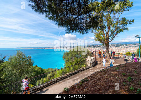 Tourists enjoy a summer day on Castle Hill overlooking the turquoise Mediterranean Sea and the city of Nice France, on the Riviera Stock Photo