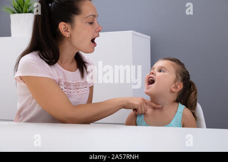 An Attractive Female Speech Therapist Helps The Girl How To Pronounce The Sounds In Office Stock Photo