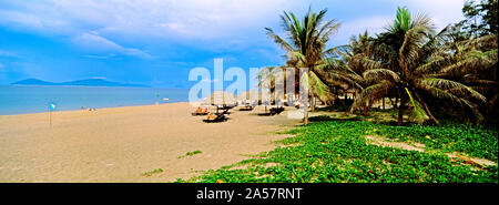 Sunshade with palm trees on the Cua Dai beach, Hoi An, Quang Nam Province, Vietnam Stock Photo