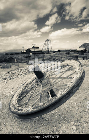 Tire with Desert Queen hoist house and mine in the background, Tonopah Historic Mining Park, Tonopah, Great Basin, Nevada, USA Stock Photo