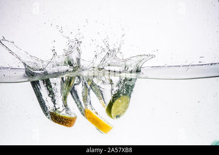 A background of bubbles forming in blue water after fruits is dropped into it. Stock Photo
