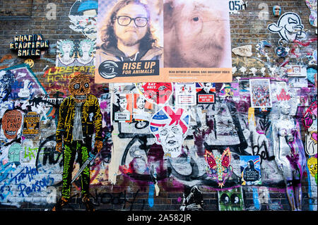London, UK. 18th Oct, 2019. A view of a wall filled with political posters.As the Brexit deadline looms, new murals and paste-ups appear on the streets of London. Brick Lane, in London's east end, is one of the most popular places to find all kind of art around the Brexit. Also in the famous district of Shoreditch, tourists walk and take photos around this political street art. Credit: Ana Fernandez/SOPA Images/ZUMA Wire/Alamy Live News Stock Photo
