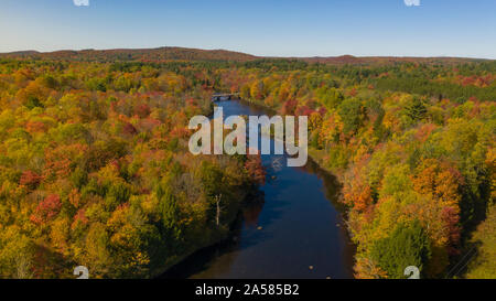 Fall color is more saturated at sunset over the Oswegatche River Adirondack Park Mountains New York Stock Photo