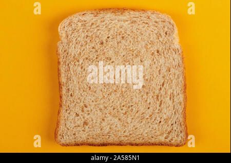 One square white bread slice top view on yellow background Stock Photo