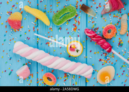 Blue wooden table full of candies, lollipops and sweets. Stock Photo