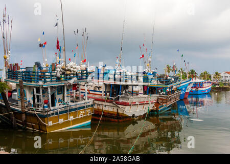 Columbo, Sri Lanka - 26 April 2011: Colourful fishing boats in the harbour. Traditional vessels ladden with nets, flags and floats. Fishing is an impo Stock Photo