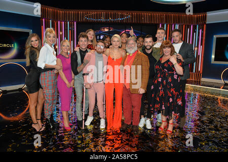 Winner Paddy Smyth (in pink), host Emma Willis (cente) and Viewer's Champion Tim Wilson celebrate with the other finalists and blocked contestants after the final of the second series of Channel 4's The Circle in Salford, Manchester. Stock Photo