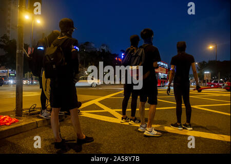 Gangs of Hong Kong protestors in sinister masks wield clubs and baseball bats on the streets of Hong Kong, goading the police Stock Photo