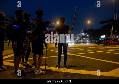 Gangs of Hong Kong protestors in sinister masks wield clubs and baseball bats on the streets of Hong Kong, goading the police Stock Photo