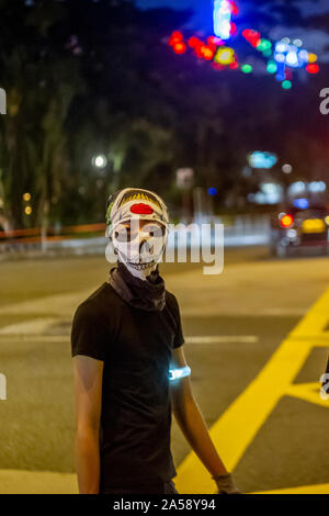 Gangs of Hong Kong protestors in sinister masks wield clubs and baseball bats on the streets of Hong Kong, goading the police Stock Photo