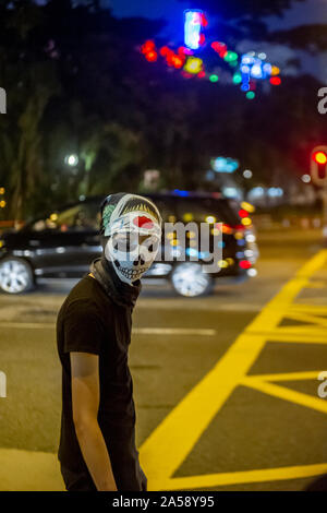 Gangs of Hong Kong protestors in sinister masks wield clubs and baseball bats on the streets of Hong Kong, goading the police Stock Photo