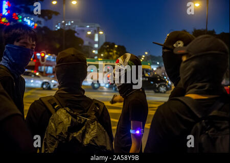 Gangs of Hong Kong protestors in sinister masks wield clubs and baseball bats on the streets of Hong Kong, goading the police Stock Photo