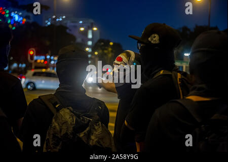 Gangs of Hong Kong protestors in sinister masks wield clubs and baseball bats on the streets of Hong Kong, goading the police Stock Photo