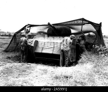 Fifth Army. Anzio Area, Italy. Dummy tank designed by British, made of rubber and inflated when used. Can be assembled in 20 minutes. When used in field can simulate tank positions. General view showing soldiers [placing] the completely assembled dummy [tank] into a camouflaged position [illeg.] recently vacated by a medium [tank] [illeg.] moving up to attack Stock Photo