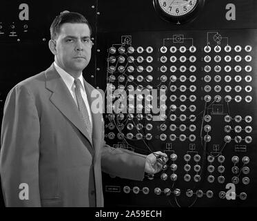 Harry Mergler stands at the control board of a differential analyzer in ...