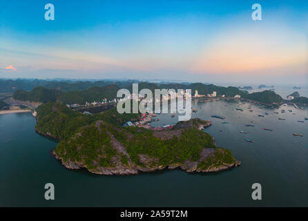 Aerial unique view Vietnam Cat Ba bay with floating fishing boats on sea, cloudscape tropical weather inspirational sunset, epic city skyline and skys Stock Photo