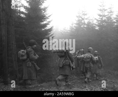 Original caption: Men of the 82nd Airborne Division move up a road through heavy fog, somewhere in Belgium. (2nd Bn., 325th Glider Reg't.) 12/20/44. Near Werbormont, Belgium. Stock Photo