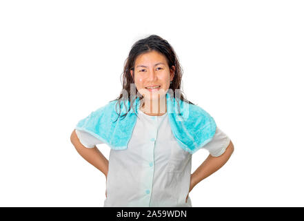 The Asian woman in blue pajamas is standing in studio with one small blue towel over her shoulder. Stock Photo