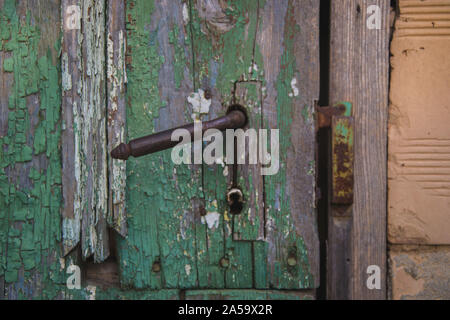 Old grungy door, door handle close-up, damaged wooden door texture Stock Photo