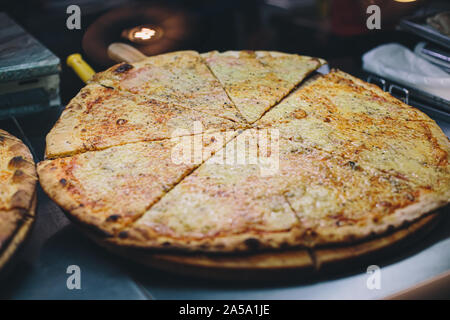 Hot pizza displayed for sale inside display case in street restaurant Stock Photo