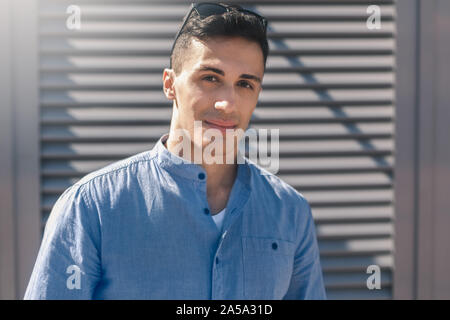 Outdoors Leisure. Stylish guy with sunglasses standing on the street smiling confident to camera close-up Stock Photo