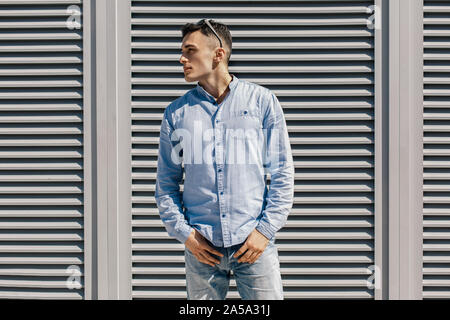 Outdoors Leisure. Stylish guy with sunglasses standing on the street posing to camera looking aside thoughtful Stock Photo