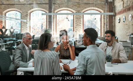 Important meeting. Group of business people discussing something and working together while sitting at the office table Stock Photo