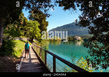 Female hiker at the side of Lake Toblino and the famous Toblino castle - Trentino Alto Adige, Italy Stock Photo