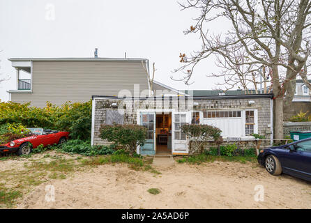 Vintage MG car with plants growing from the engine on the beach outside a dilapidated art gallery in Provincetown (P-Town), Cape Cod, New England, USA Stock Photo