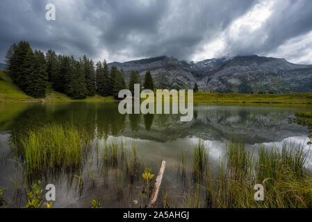 Les Diablerets reflecting in the water surface of Lac Retaud Stock Photo