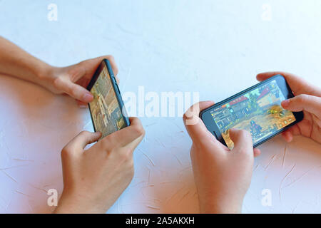 Bishkek, Kyrgyzstan - January 17, 2019: Two friends play pubg coop multiplayer battle royale game on iPhone and Android. Gameplay action Stock Photo