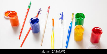 Kids creativity. Colorful finger paints set and paint brushes on white color background, banner Stock Photo