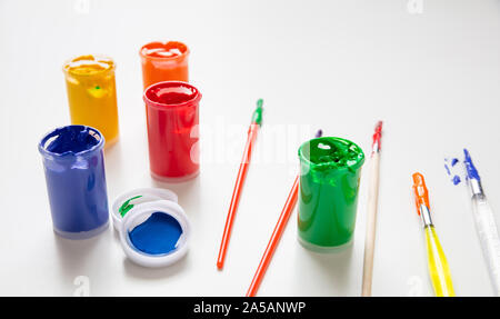 Kids creativity. Colorful finger paints set and paint brushes on white color background Stock Photo