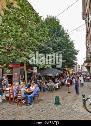 BRUSSELS, BELGIUM - JULY 27, 2014: People drink, eat and talk on the terrace of a cafe in the Old Market area of Brussels. a group of musicians play a Stock Photo