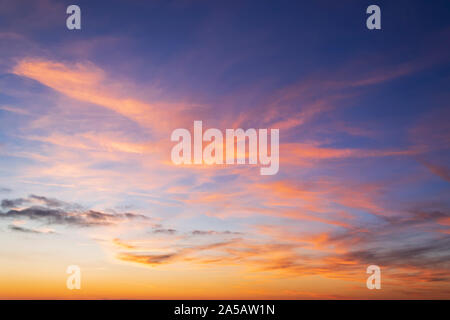Beautiful orange clouds on a golden blue sky during sunset. Scenic sundown cloudscape for background. Afterglow of sunset. Beauty in nature. Stock Photo