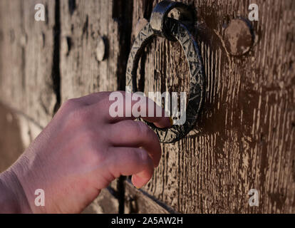 Woman knocks with a round knocker on the door, close-up Stock Photo