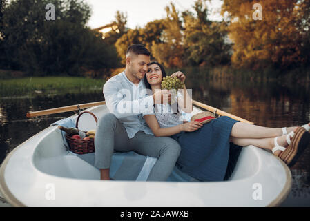 Love couple hugs in a boat on quiet lake Stock Photo