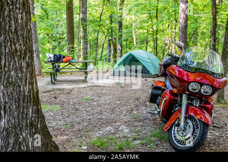 LAUDERDALE, AL, USA-4 MAY 2015: A Harley Davidson motorcycle parked in in front of a campsite, with tent in background, and gear on a picnic table. Stock Photo